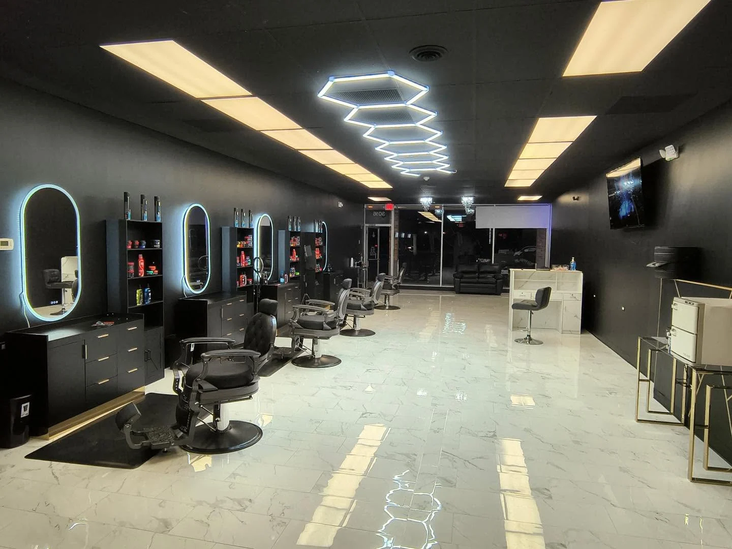 Axis Cuts interior with black barber chairs, illuminated mirrors and geometric ceiling lights