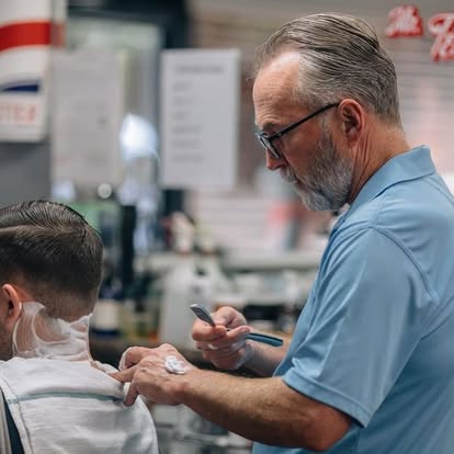 A barber at Classic Cuts and Shaves finishing a haircut