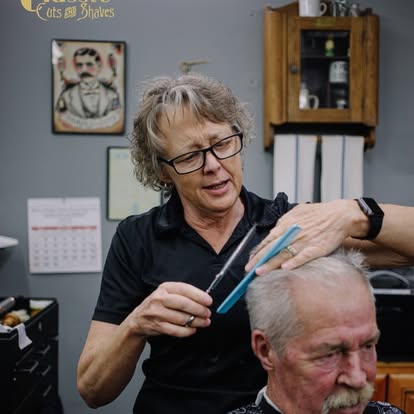 A barber at Classic Cuts and Shaves working with a client