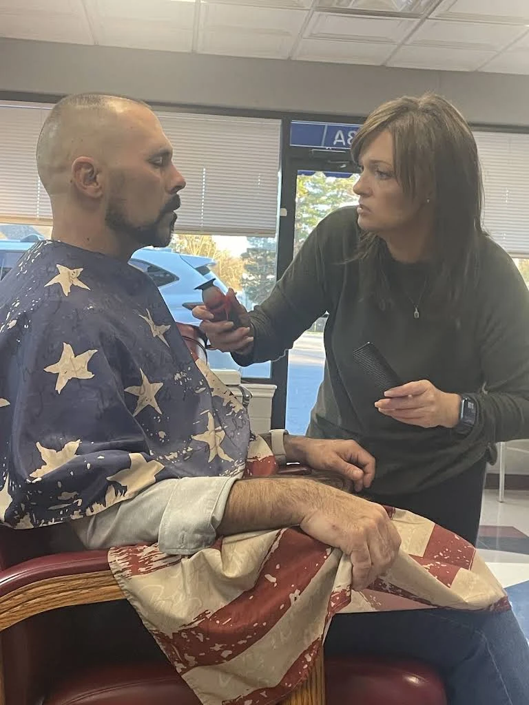 A barber working with an adult customer inside Jack’s Barber Shop